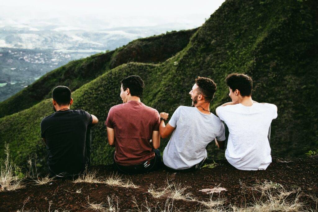 Teenagers on a camping trip sitting together and looking at a mountain