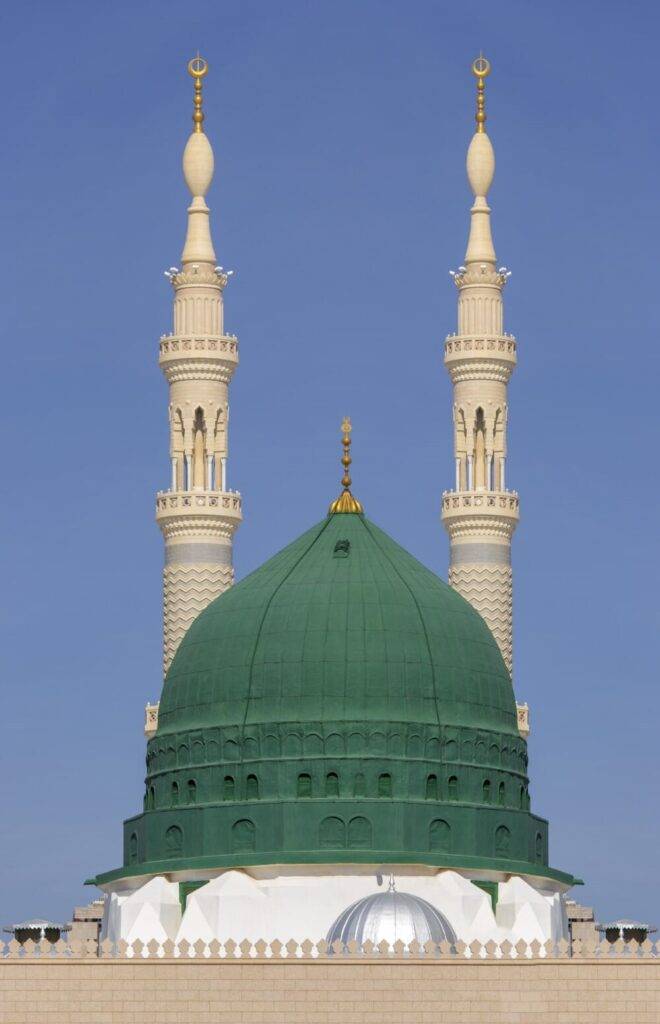 Photo of the Prophet Muhammad's mosque in Medina,with two tall minarets and a green dome